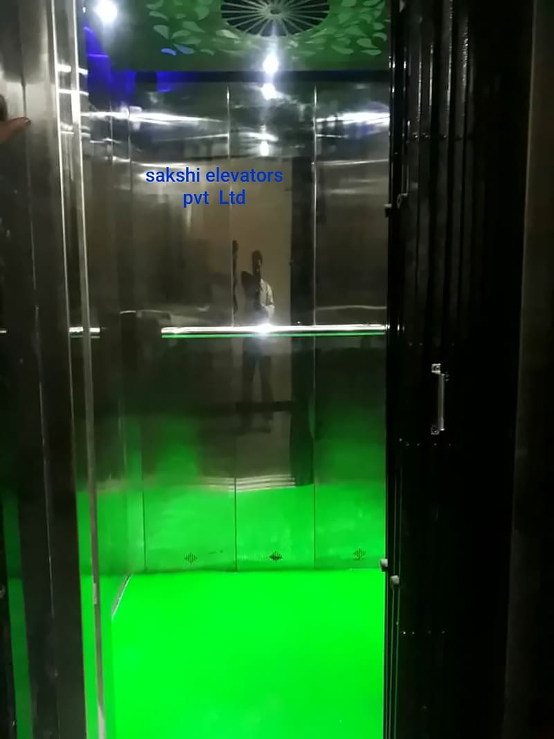 Glass-walled lift cabin with green LED floor lighting
