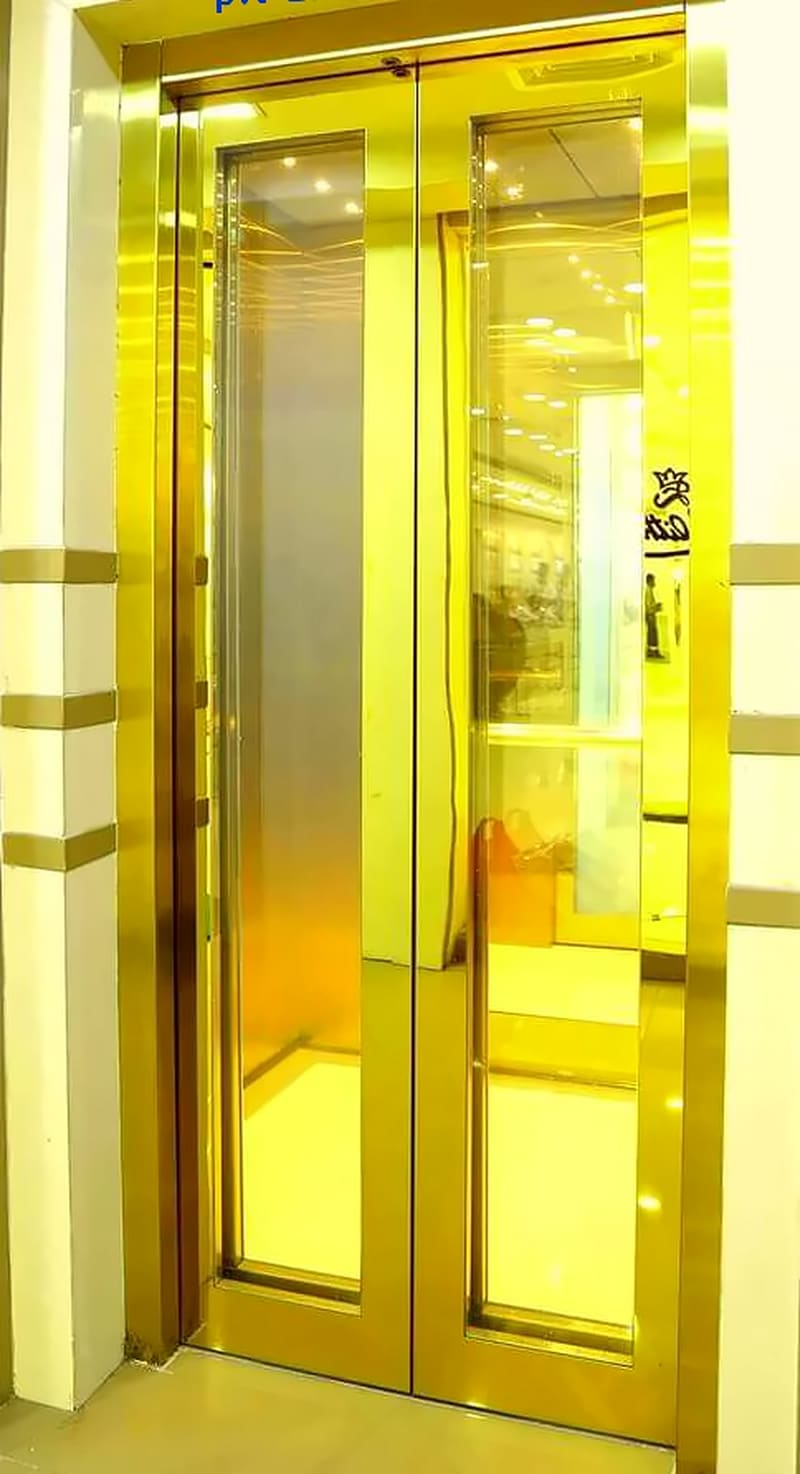 Gold-framed glass lift doors